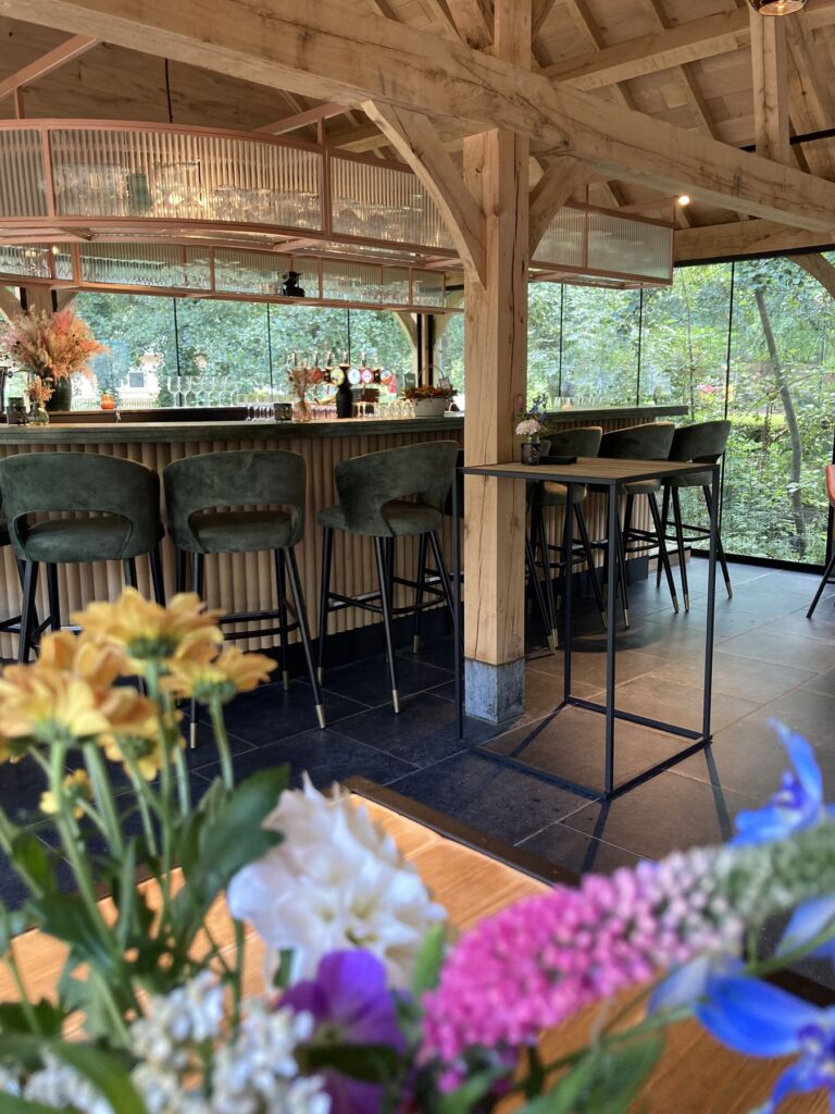 De bar overdag met grote ramen op het groen