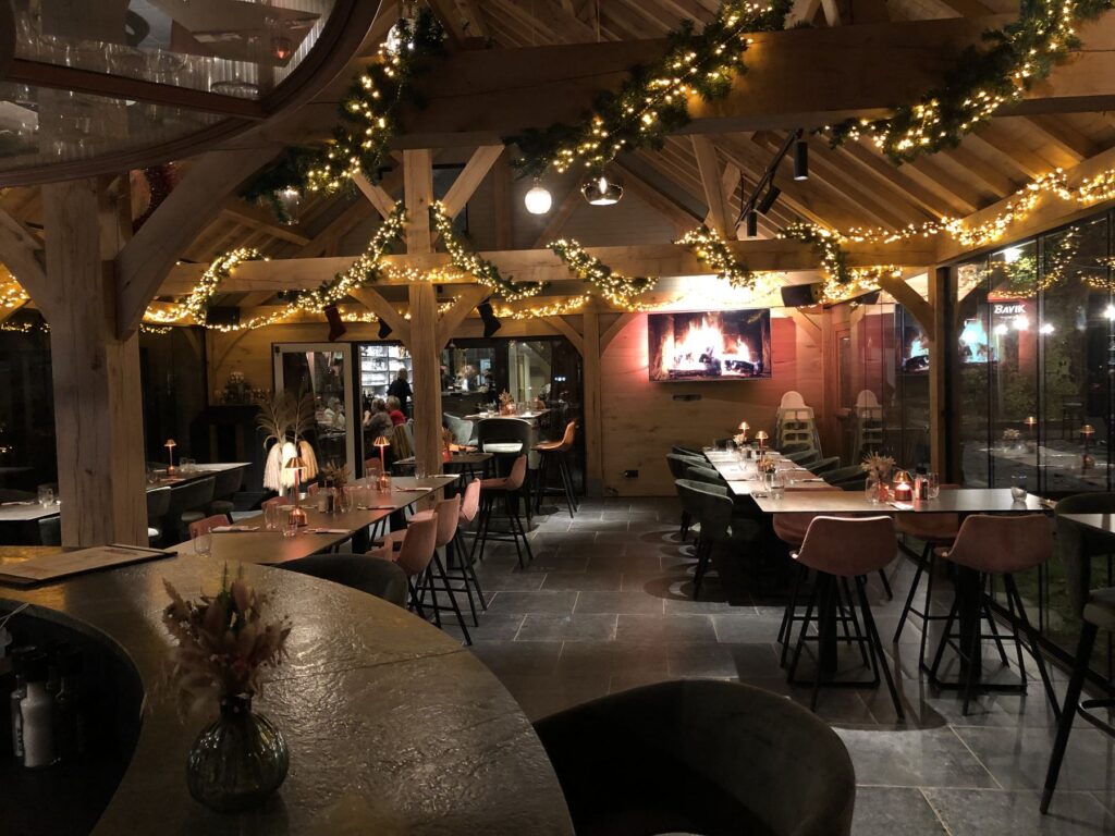 Het interieur bij avond met lichtjes, eiken spanten en open haard