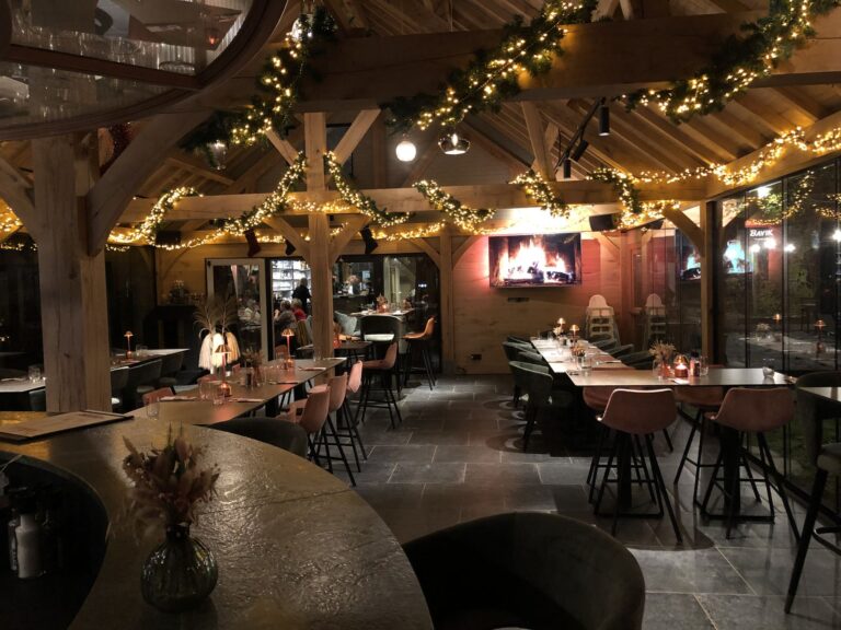 Het interieur bij avond met lichtjes, eiken spanten en open haard
