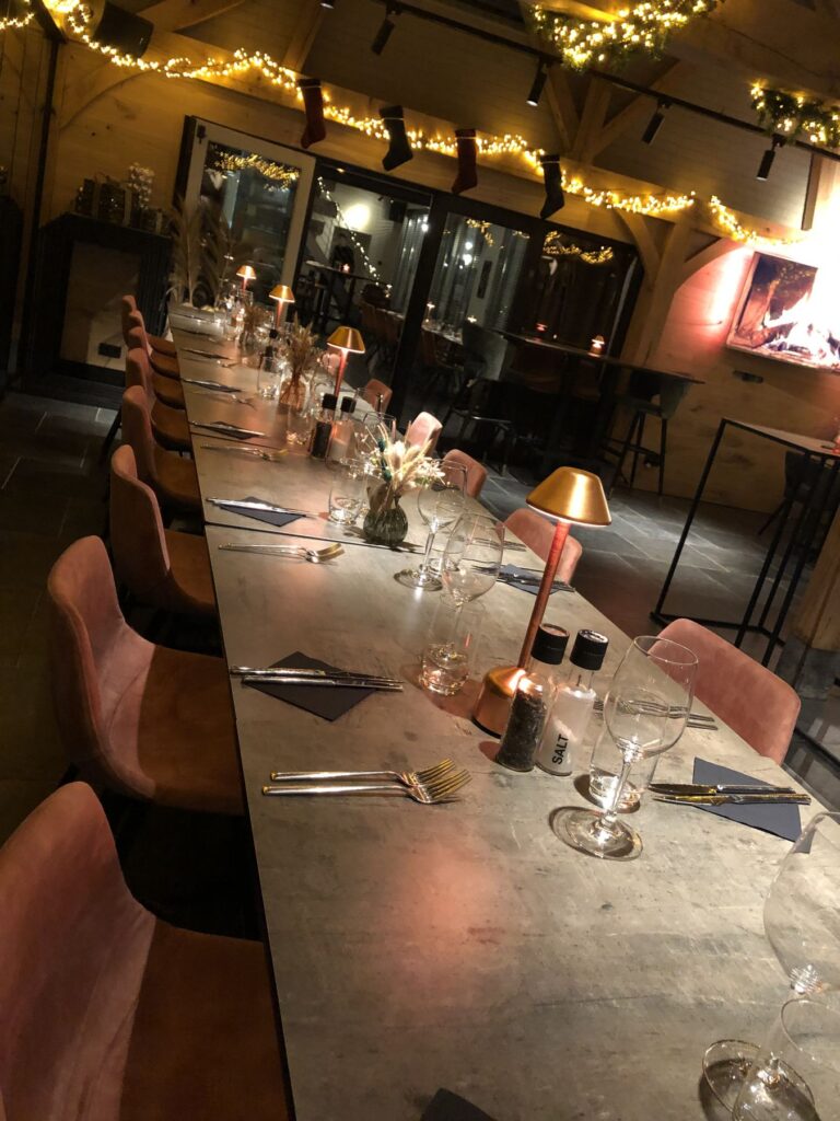 Lange gedekte tafel met roze fluwelen stoelen